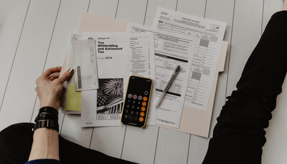 A calculator, glasses and financial paperwork on a desk
