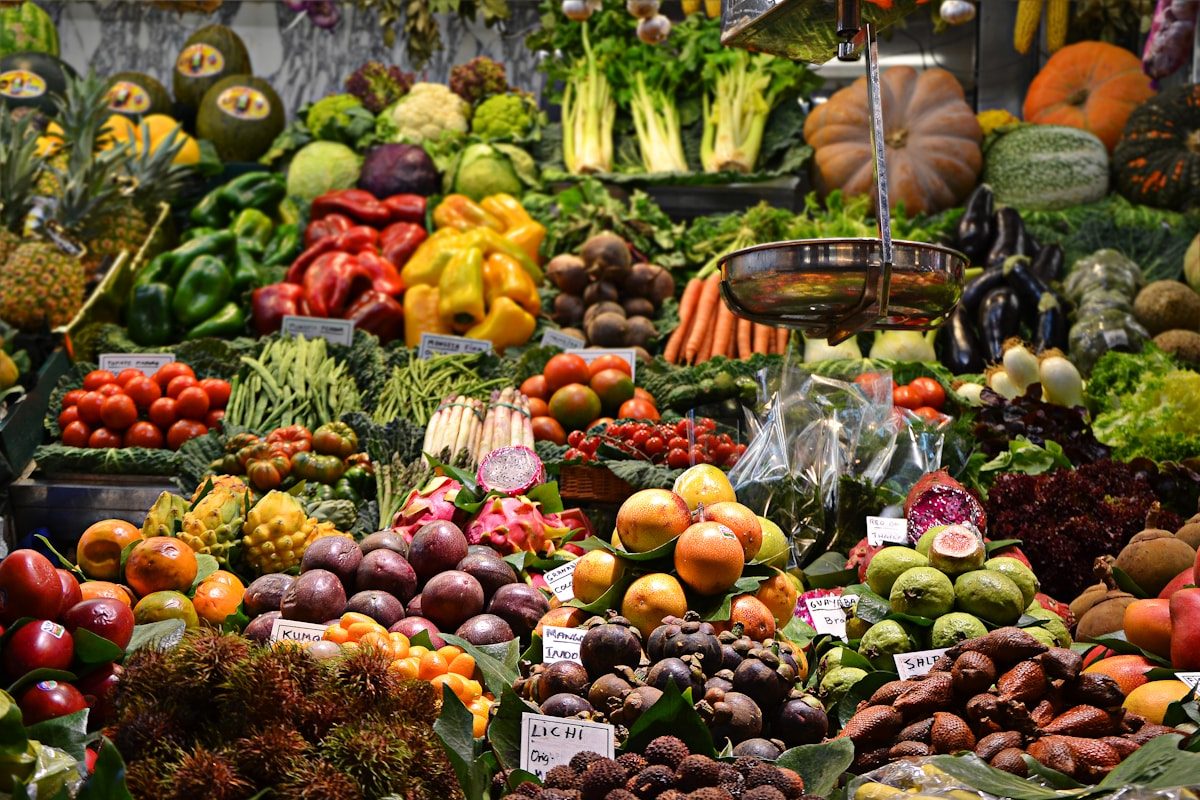 A busy produce market with stacked fruit and vegetables